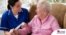 A caregiver demonstrates wound care by wrapping a senior client’s wound.