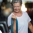 An older woman uses a resistance band to exercise, representing how staying active can help older adults keep their blood pressure in a healthy range.