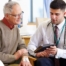 An older man talks with a doctor representing the effective communication that family caregivers should endeavor to have.