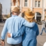 2 older adults hug while on vacation representing the successful outing that can still happen while caring for elderly loved ones.